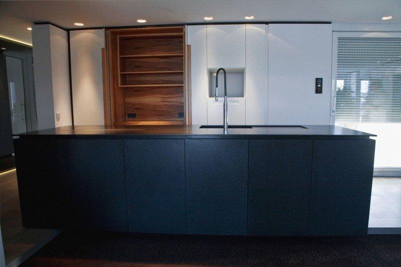 Küche in weiß mit Holzelement und Kochinsel in schwarz 